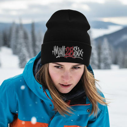 Person wearing a blue and orange jacket with a black beanie in a snowy landscape