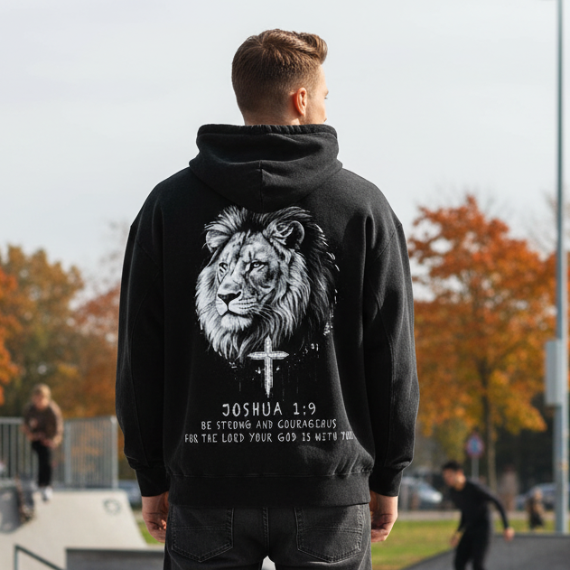 Person wearing a black hoodie with a lion graphic and text at a skate park.